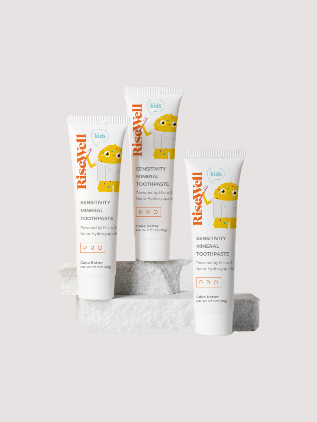 Three tubes of RiseWell toothpaste on a light gray background
