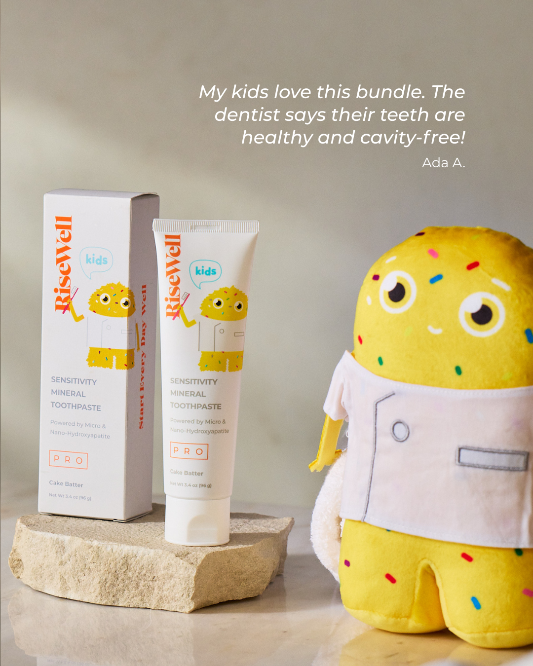 RiseWell kids toothpaste and packaging with a plush toy on a neutral background