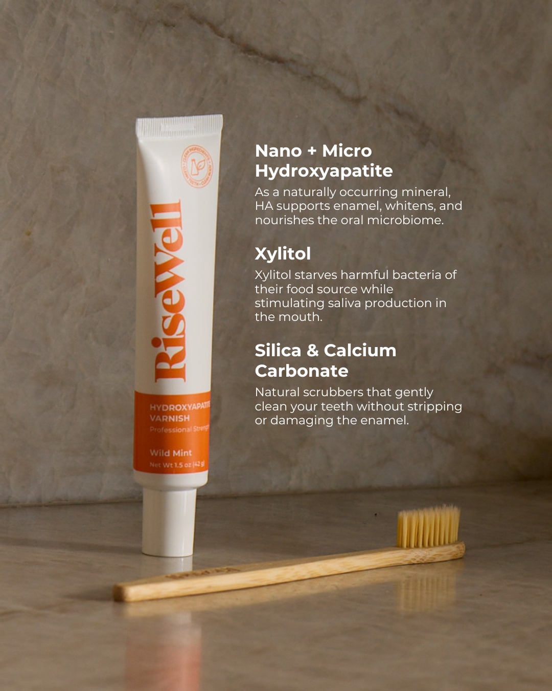 RiseWell toothpaste tube with a wooden toothbrush on a neutral background